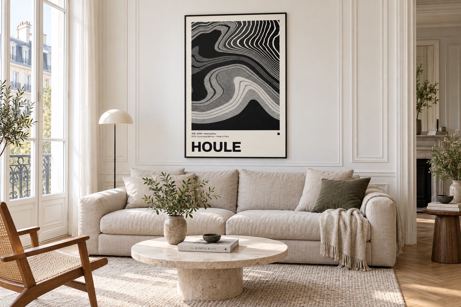 Black and cream Houle poster above a linen sofa in a bright Paris sitting room
